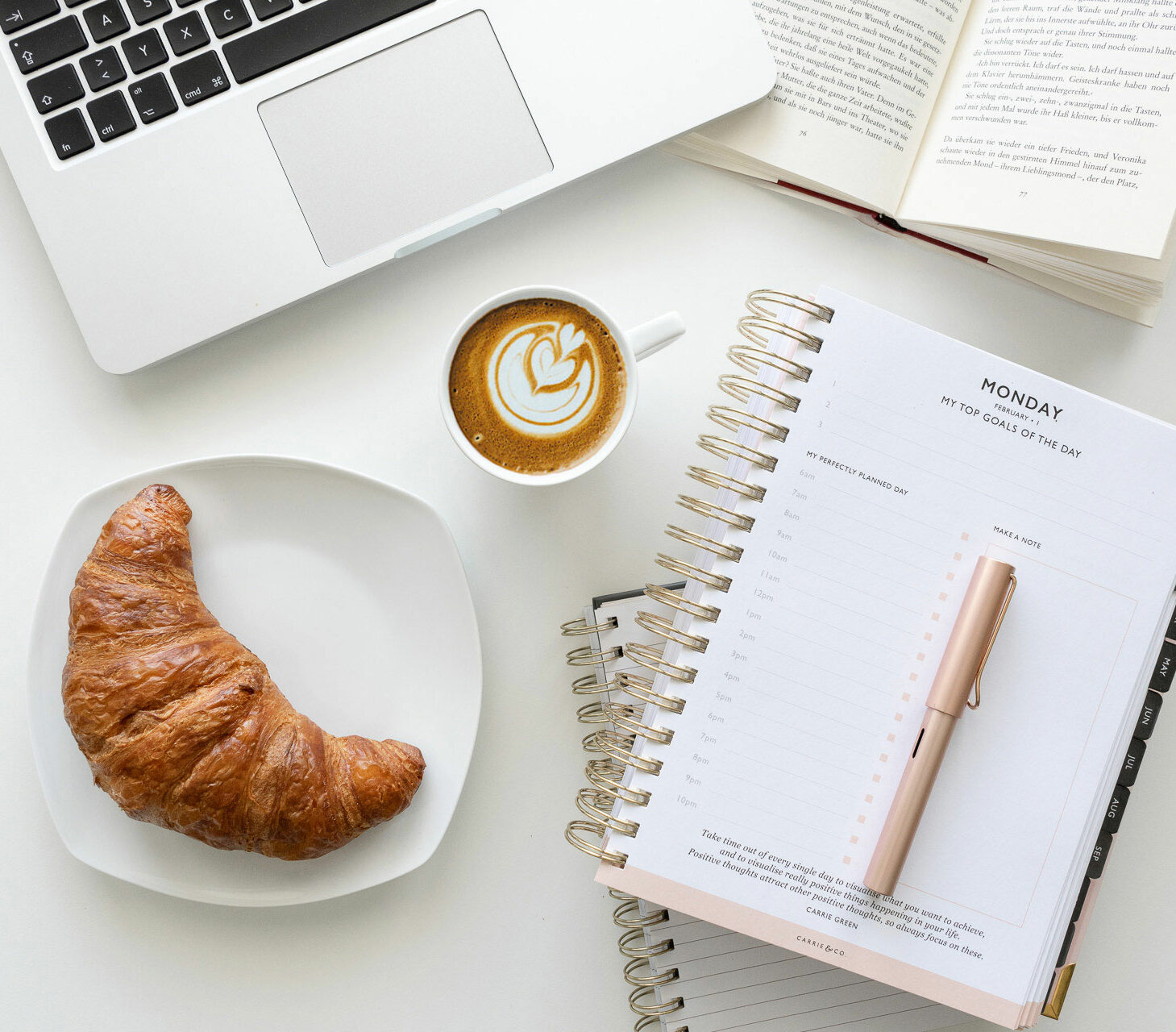 Kalender mit Kaffee und Croissant