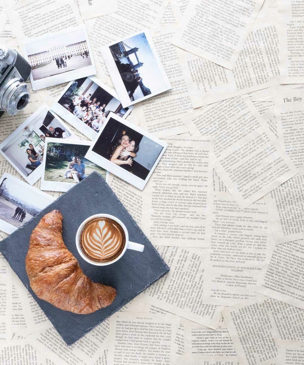 Buchseiten mit Fotos, Croissant und Kaffee